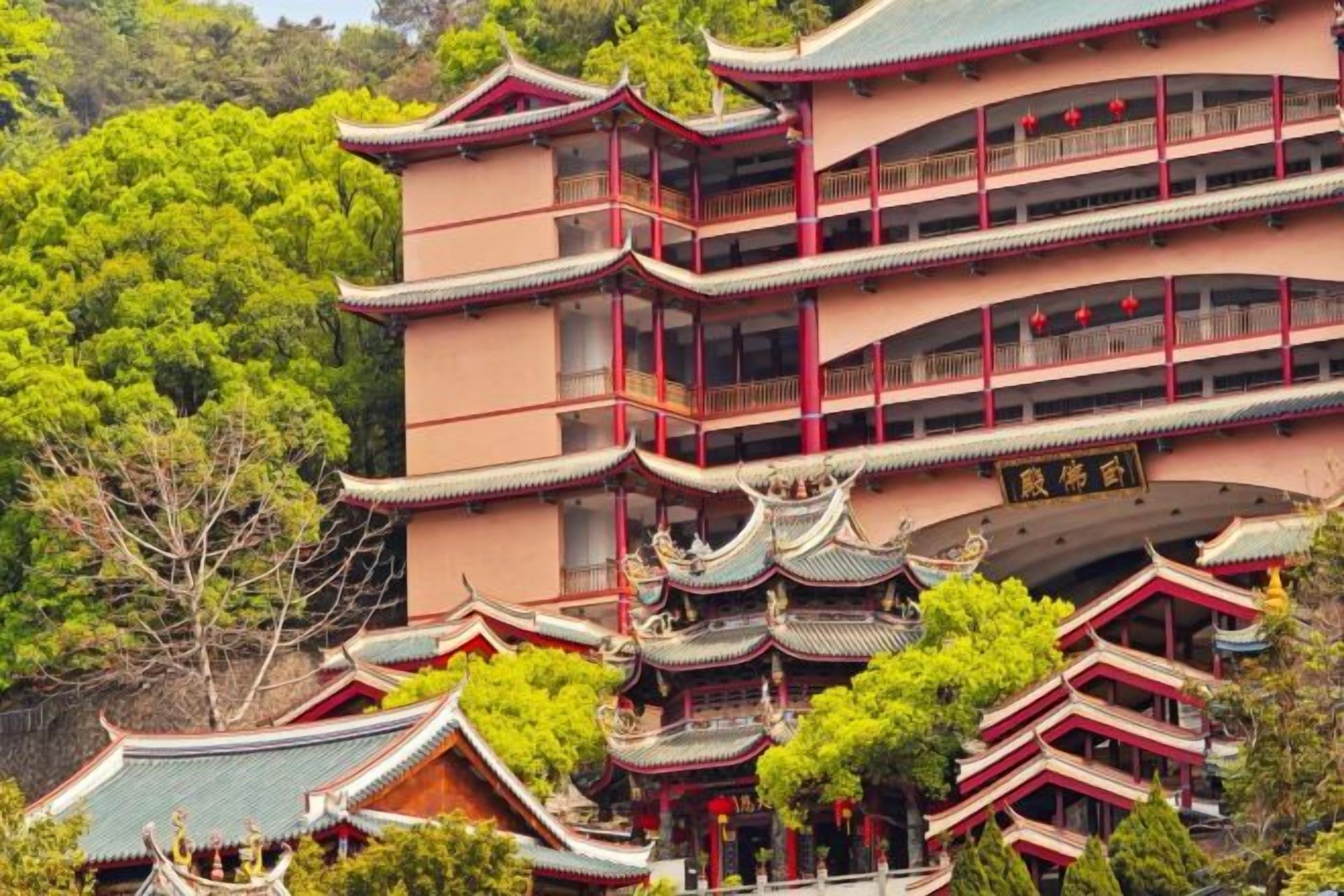A traditional multi-story building with a symmetrical facade, multiple balconies, and a central entrance with a curved roof.