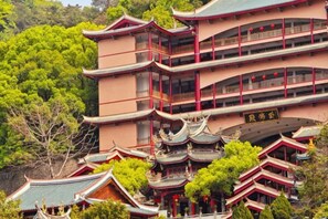 A traditional multi-story building with a symmetrical facade, multiple balconies, and a central entrance with a curved roof. - Maple, Longyan, Wanda Plaza (Longyan)