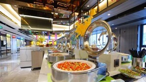 A buffet setup in a modern hotel with multiple food stations and a clean, contemporary design. - Maple, Longyan, Wanda Plaza (Longyan)