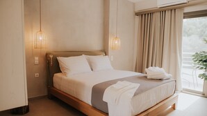 Een goed verlichte slaapkamer met een houten bed, witte lakens en uitzicht op groen.