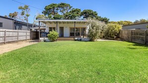 A single-story house with a covered porch, a fenced backyard, and a small front yard.