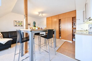 Un espace de vie moderne comprenant un coin repas, une cuisine et un coin salon.