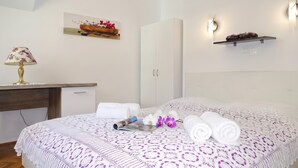 Un dormitorio ordenado con una cama, un escritorio, una lámpara y una estantería en la pared.