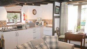 A cozy living room with a sofa and a dining table set for two.