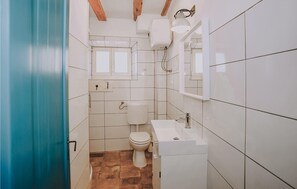 A small bathroom with a toilet, sink, and a window above the toilet. - Gorgeous home in Preko with WiFi (Preko)