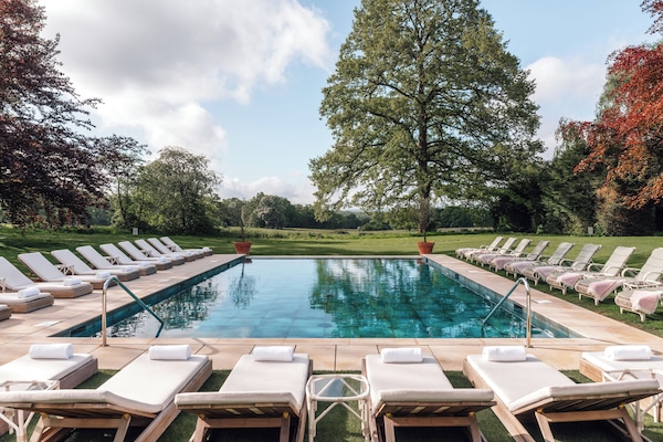 Een binnenzwembad, een buitenzwembad en ligstoelen