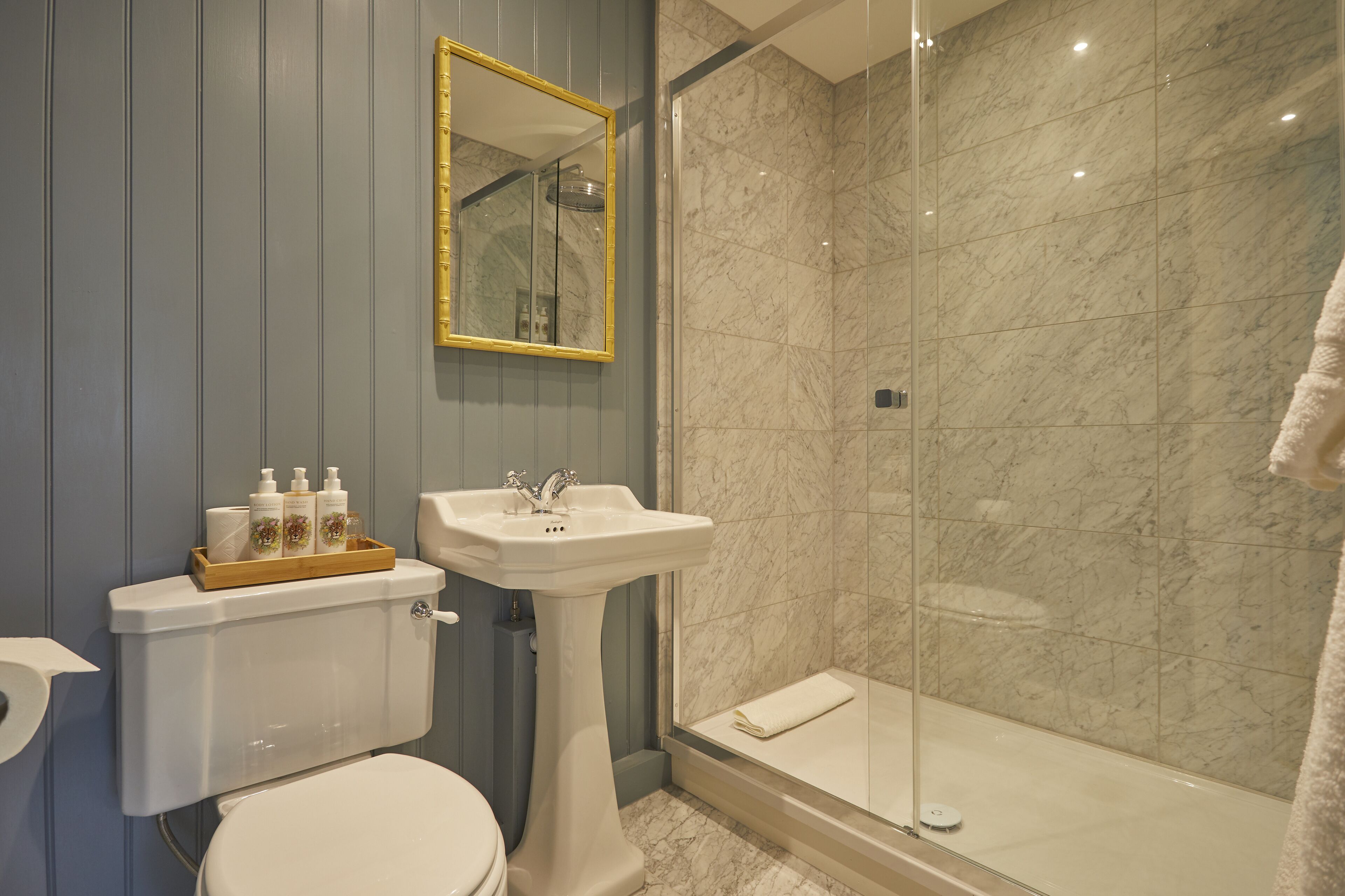 A bathroom with a toilet, sink, and shower.