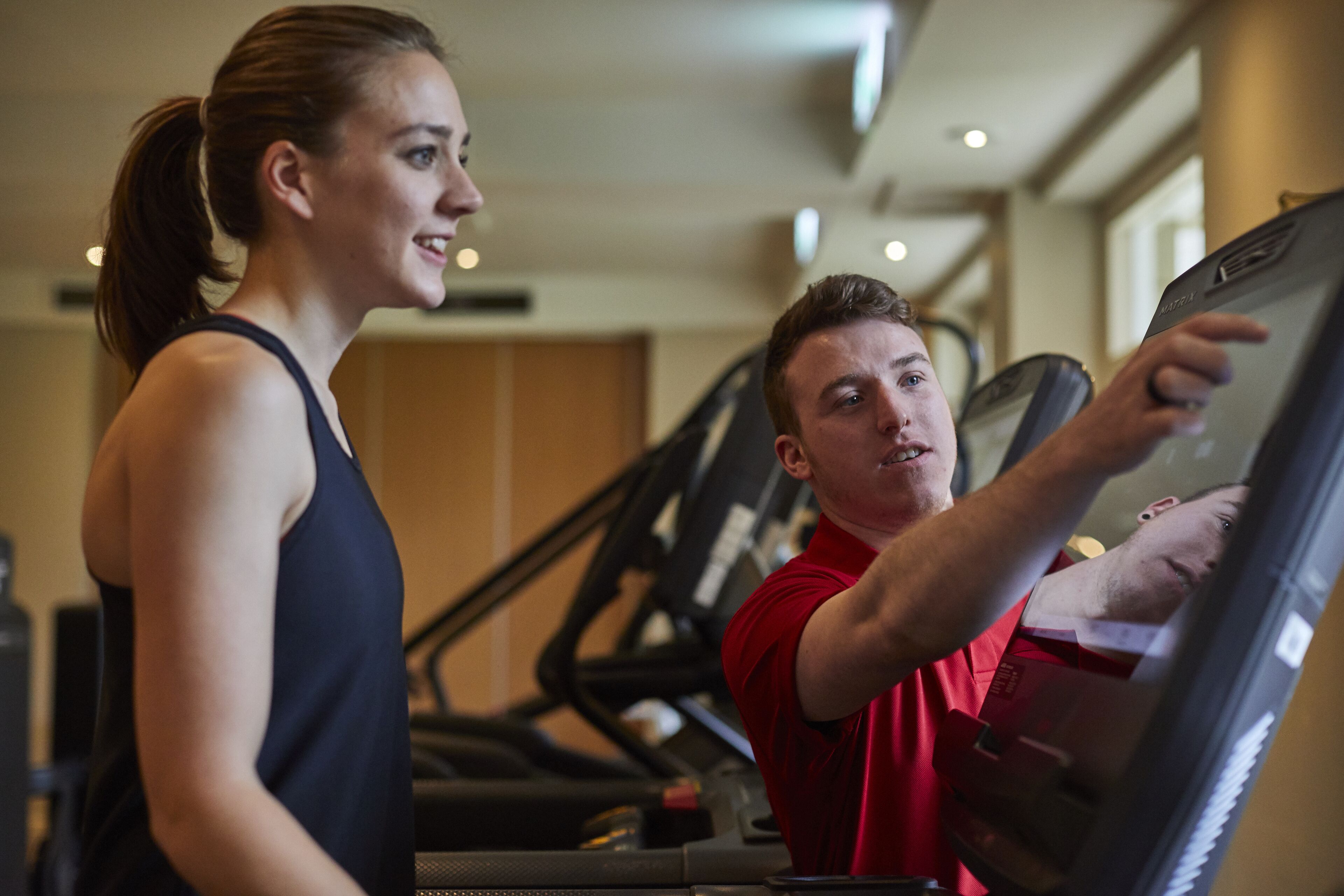 A gym with treadmills and a person using a treadmill.