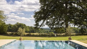 A rectangular swimming pool with a tiled edge, surrounded by a grassy area and trees. - The Retreat, Elcot Park (Newbury)