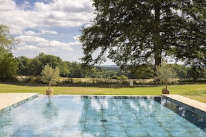 Una piscina cubierta, una piscina al aire libre, tumbonas