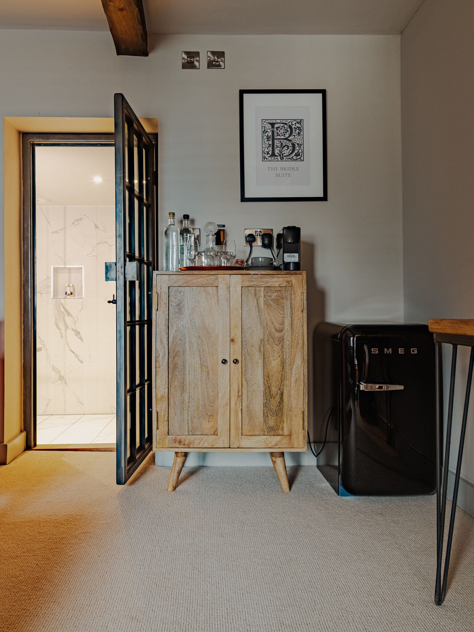 A room with a wooden cabinet, a black appliance, and a framed picture on the wall.