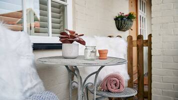 A small round table with a potted plant, a glass jar, and a terracotta pot.