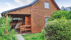 Eine Holzhütte mit Veranda, Schornstein und einem kleinen Fenster.