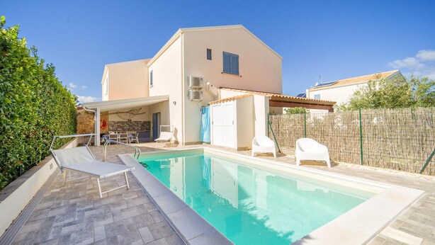 A swimming pool with lounge chairs, a covered patio, and a stone wall. - Stunning home in Cornino (Cornino)