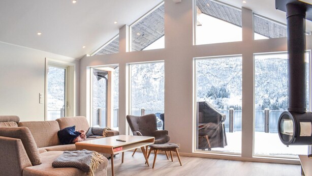 A spacious living room with a large window, a sofa, a coffee table, and a fireplace. - Lovely home in Masfjordnes with WiFi (Masfjordnes)