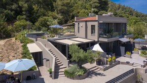 A modern villa with a rooftop terrace, outdoor seating, and a staircase leading to the upper level. - Anmian Suites (Sithonia)