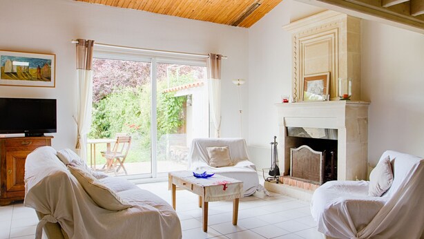 A living room with a television, two chairs, a table, and a fireplace. - House for 6 in the heart of Saint Martin (Saint-Martin-de-Ré)