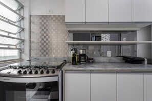 A modern kitchen with a gas stove, a coffee maker, and a microwave.