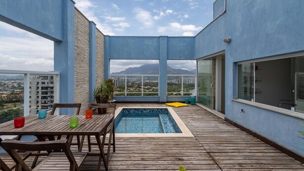 A rooftop terrace with a swimming pool, wooden deck, and a table with chairs. - Coverage in Barra da Tijuca for 6 People Lc2207 (Rio de Janeiro)