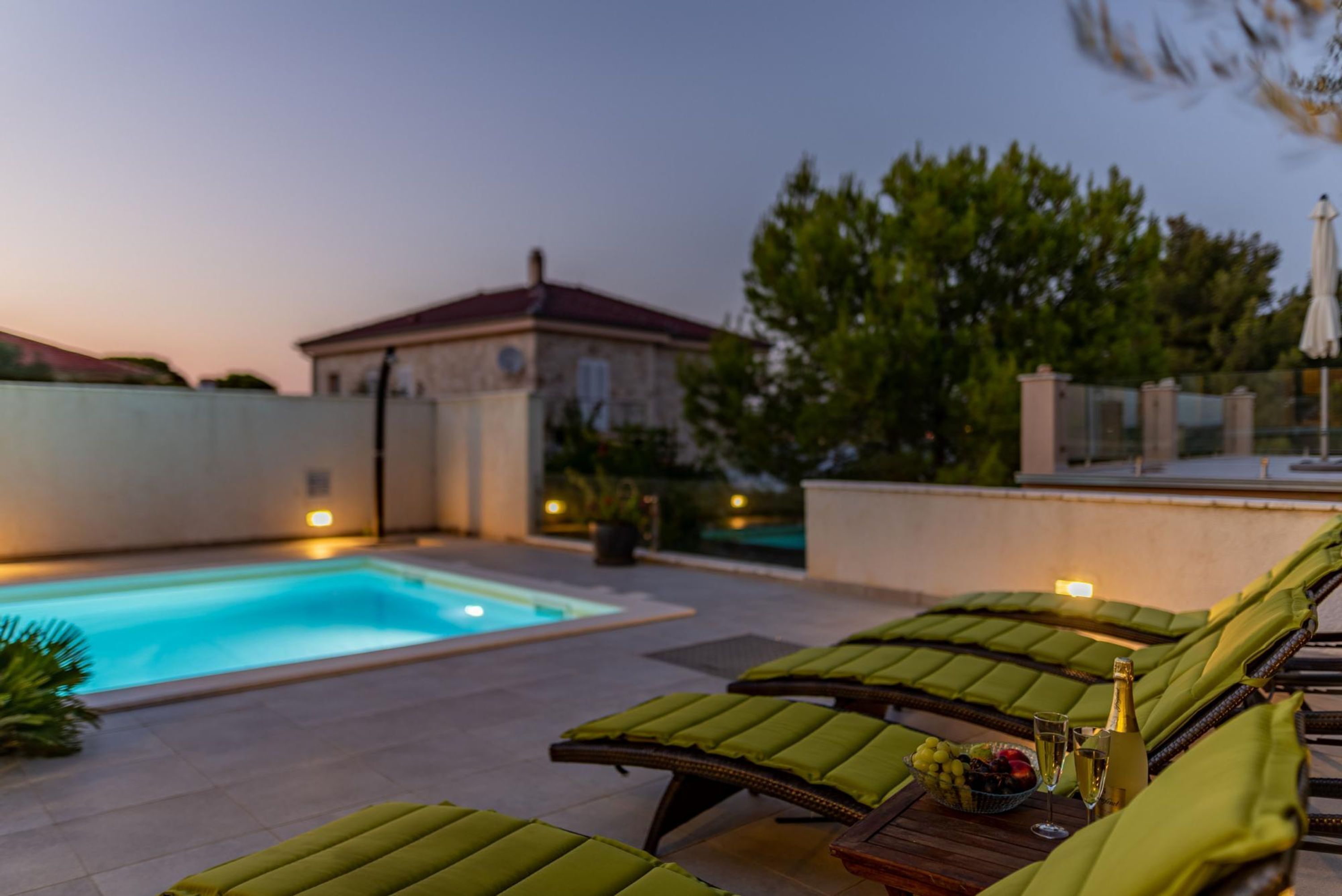 A poolside area with lounge chairs and a table with drinks.