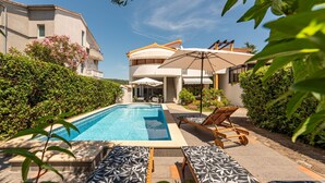 Ein Poolbereich mit Liegestühlen und einer Pergola.
