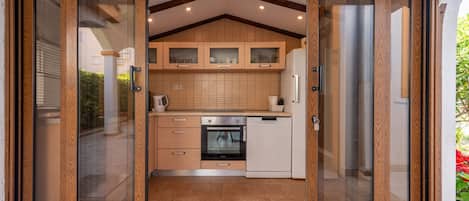 A kitchen with wooden cabinets, a built-in oven, and a dishwasher.