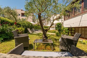 A courtyard with wicker furniture, a small table, and a tree. - Villa Petra Zadarvillas (Bibinje)