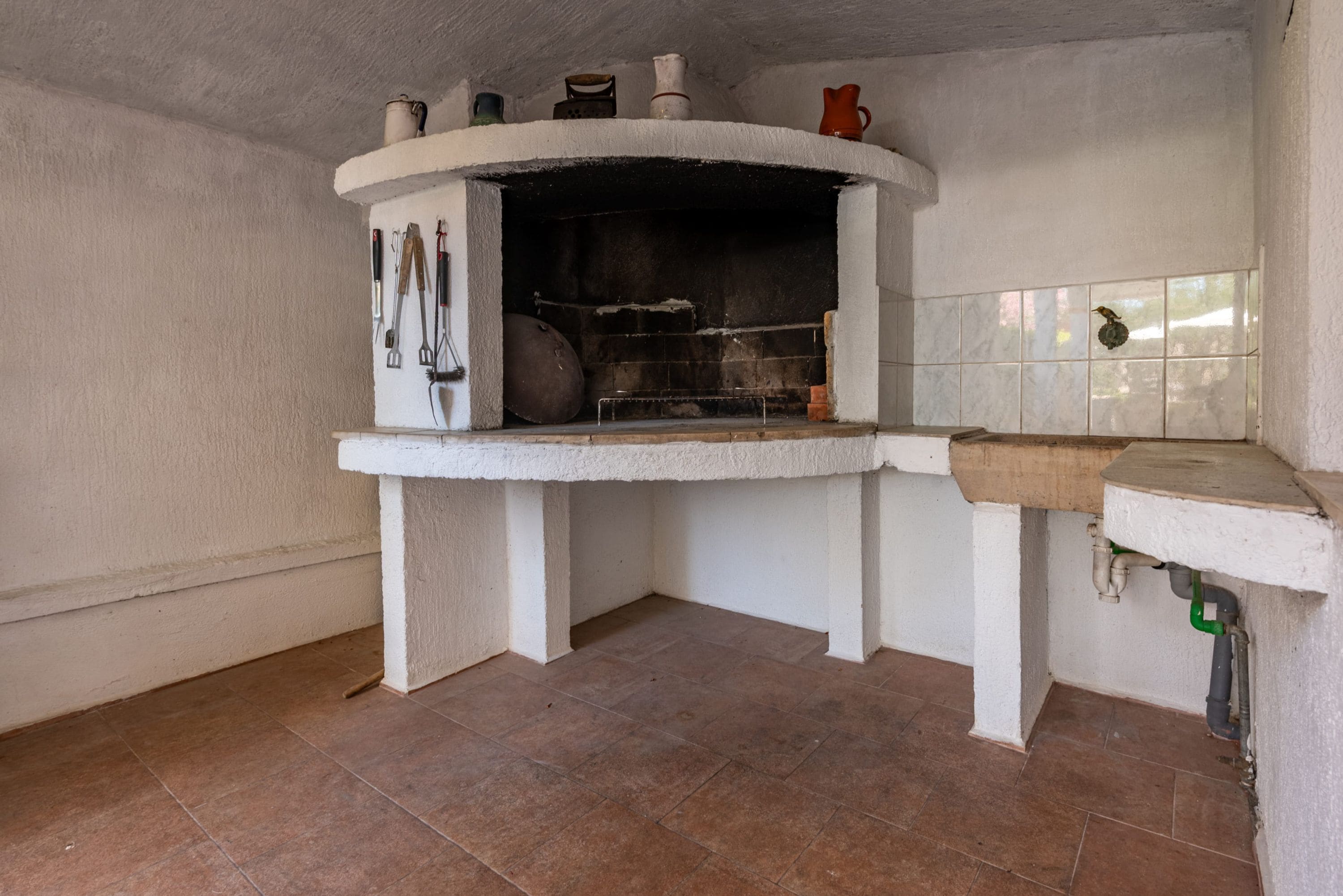 A kitchen with a built-in oven, a sink, and a tiled backsplash.