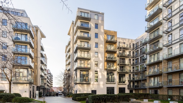 A modern apartment building with multiple balconies, a paved walkway, and well-maintained landscaping. - Beautiful Bow Apartment (London)