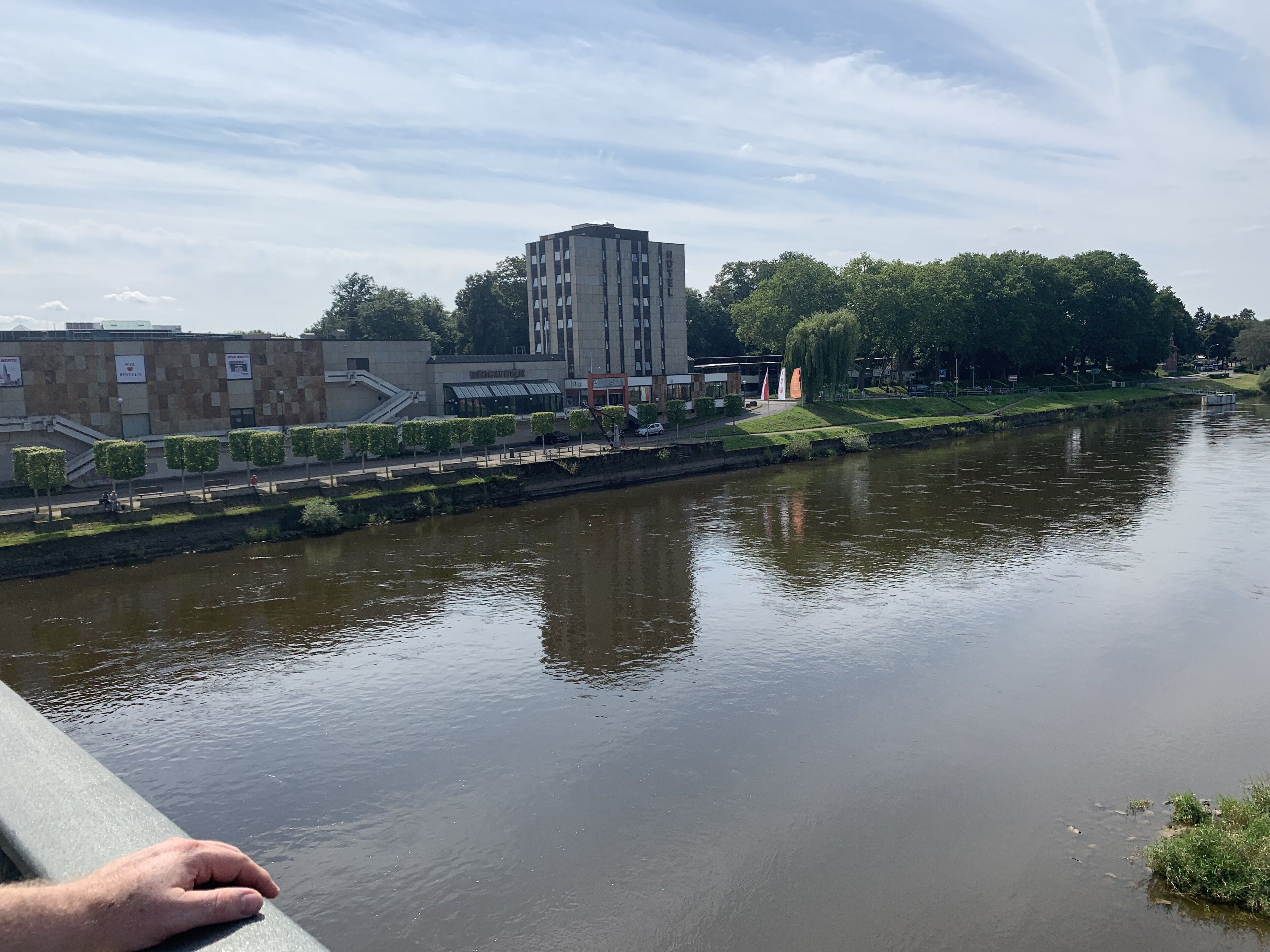 A river with a bridge, buildings, and trees in the background.