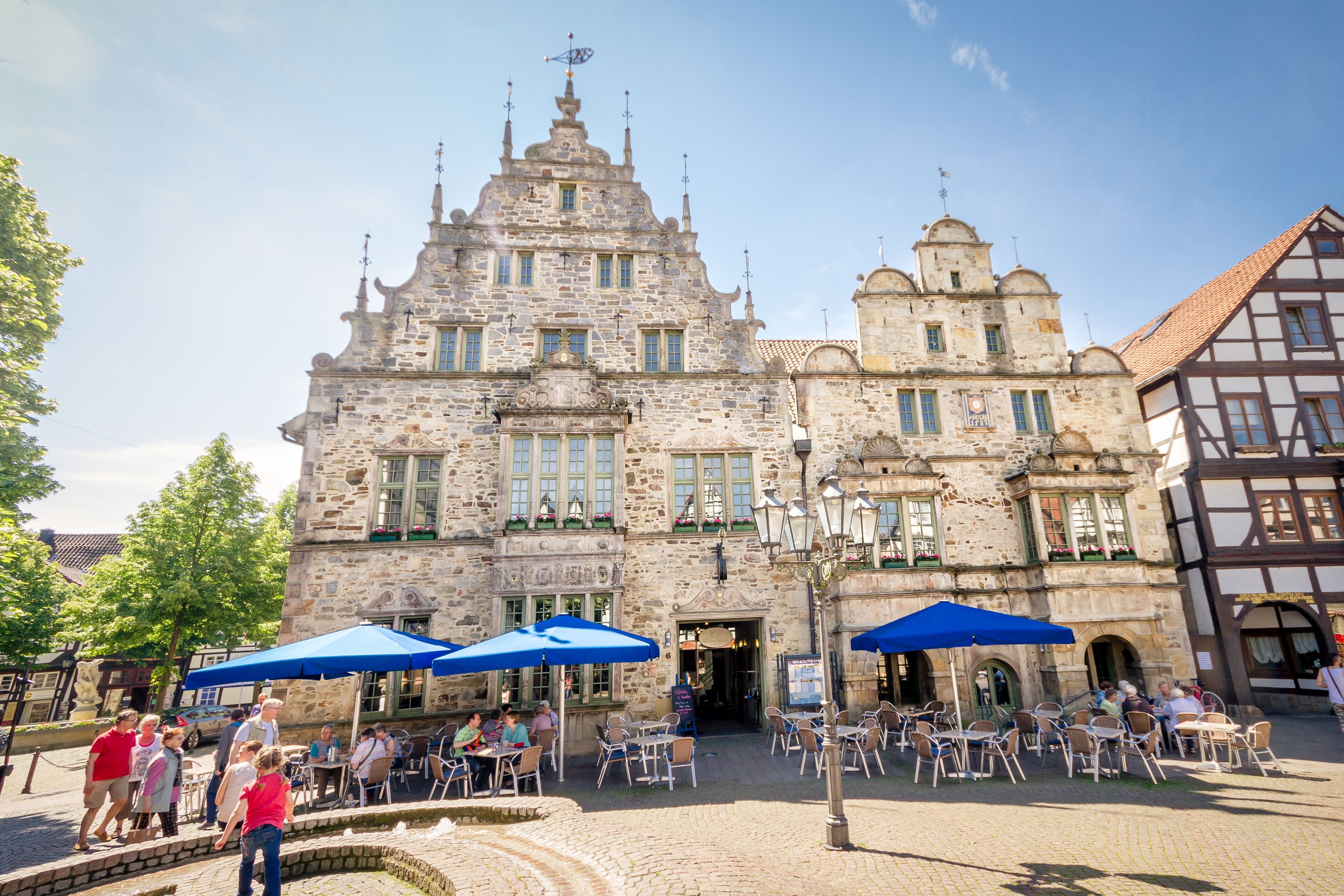 A historic stone building with a traditional European architectural style, featuring multiple windows and a central entrance.