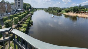 Vista del río con un bote, un puente y un edificio con un letrero.