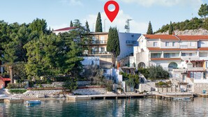 Une ville côtière avec des bâtiments, un port de plaisance et un marqueur de localisation rouge.
