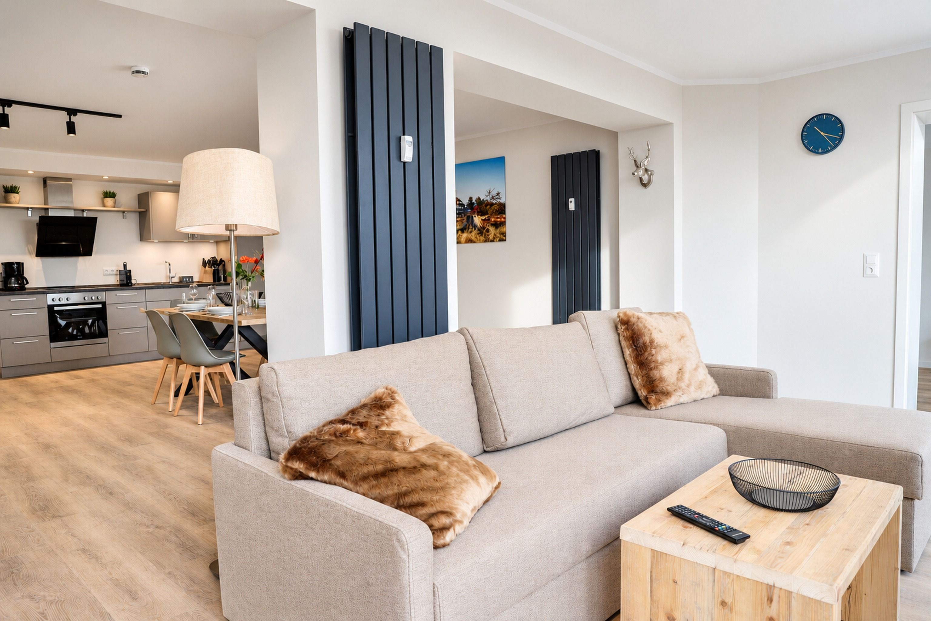 A modern living room with a sofa, a coffee table, and a remote control.