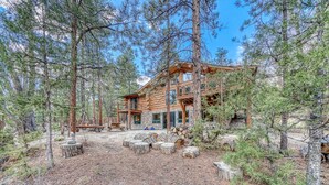 A log cabin with a deck and outdoor seating area surrounded by tall pine trees. - Inviting and Relaxing-Cliffs and Streams! (Nathrop)