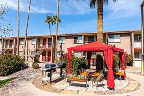 A motel with a covered patio area, outdoor seating, and a barbecue grill. - 223-Fully Furnished with WiFi by RedAwning (Scottsdale)