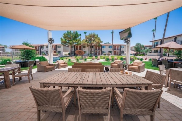 Relax in style with a dining table and comfortable wicker chairs on this shaded patio.