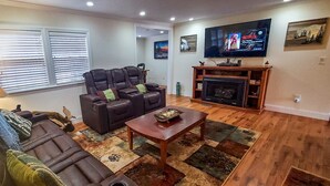 Una sala de estar con chimenea, televisor y sofá.