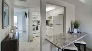 A modern kitchen with white cabinets, a granite countertop, and stainless steel appliances. - 111 Fully Furnished 1BR Suite-Prime Location! by RedAwning (Scottsdale)