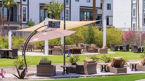 An outdoor patio area with wicker furniture, a large umbrella, and a pool. - 108 Fully Furnished 1BR Suite-Prime Location! by RedAwning (Scottsdale)