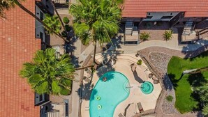 An aerial view of a hotel with a central swimming pool, surrounded by palm trees and lounge chairs. - 108 Fully Furnished 1BR Suite-Prime Location! by RedAwning (Scottsdale)