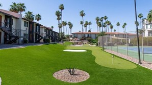 Zona residencial con casas, palmeras, un campo de golf y una cancha de tenis.