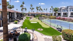 A golf course with a putting green, a tennis court, and a patio area with outdoor seating. - 114 Fully Furnished 1BR Suite-Prime Location! by RedAwning (Scottsdale)