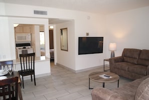 Relax in this stylish living room with a flat-screen TV, comfortable sofa, and dining area.