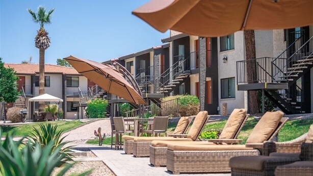 A hotel courtyard with outdoor seating, a palm tree, and a staircase leading to an upper level. - 205 Fully Furnished 1BR Suite-Prime Location! by RedAwning (Scottsdale)