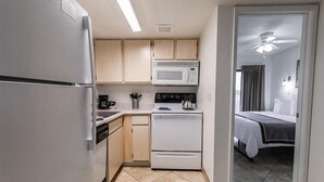 A compact kitchen with a refrigerator, microwave, stove, and dishwasher. - 205 Fully Furnished 1BR Suite-Prime Location! by RedAwning (Scottsdale)