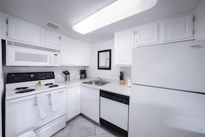Enjoy cooking in this well-equipped kitchen with a microwave, stove, sink, and dishwasher.