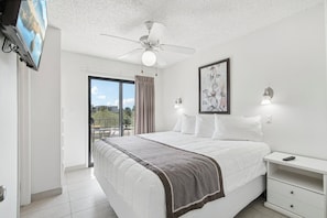 A bedroom with a bed, a ceiling fan, a TV, a nightstand, and a painting. - 227-Fully Furnished with WiFi by RedAwning (Scottsdale)