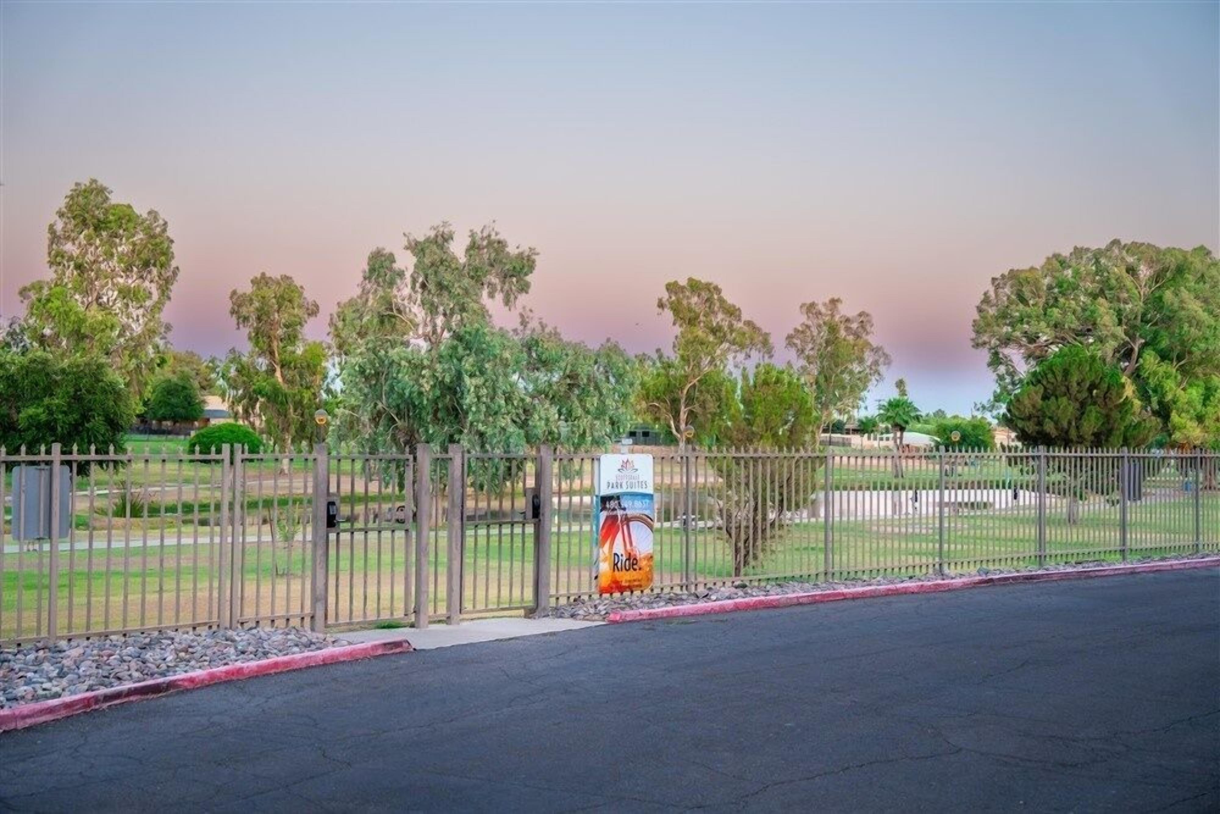 A fenced outdoor area with a sign for 'Park Suites' and a 'Ride' service.