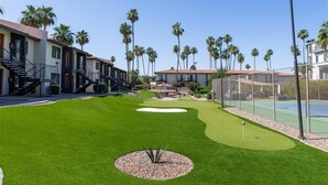A golf course with a well-maintained green, a sand bunker, and a tennis court. - 116 Fully Furnished 1BR Suite-Prime Location! by RedAwning (Scottsdale)